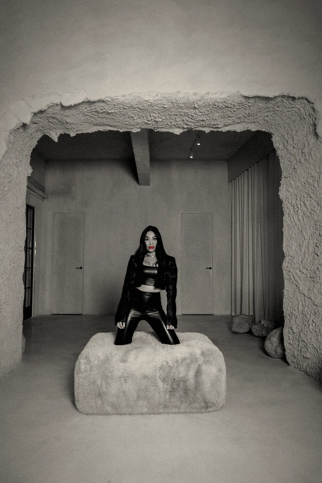 Chayenne Mallari kneeling on a faux fur block inside a plaster archway