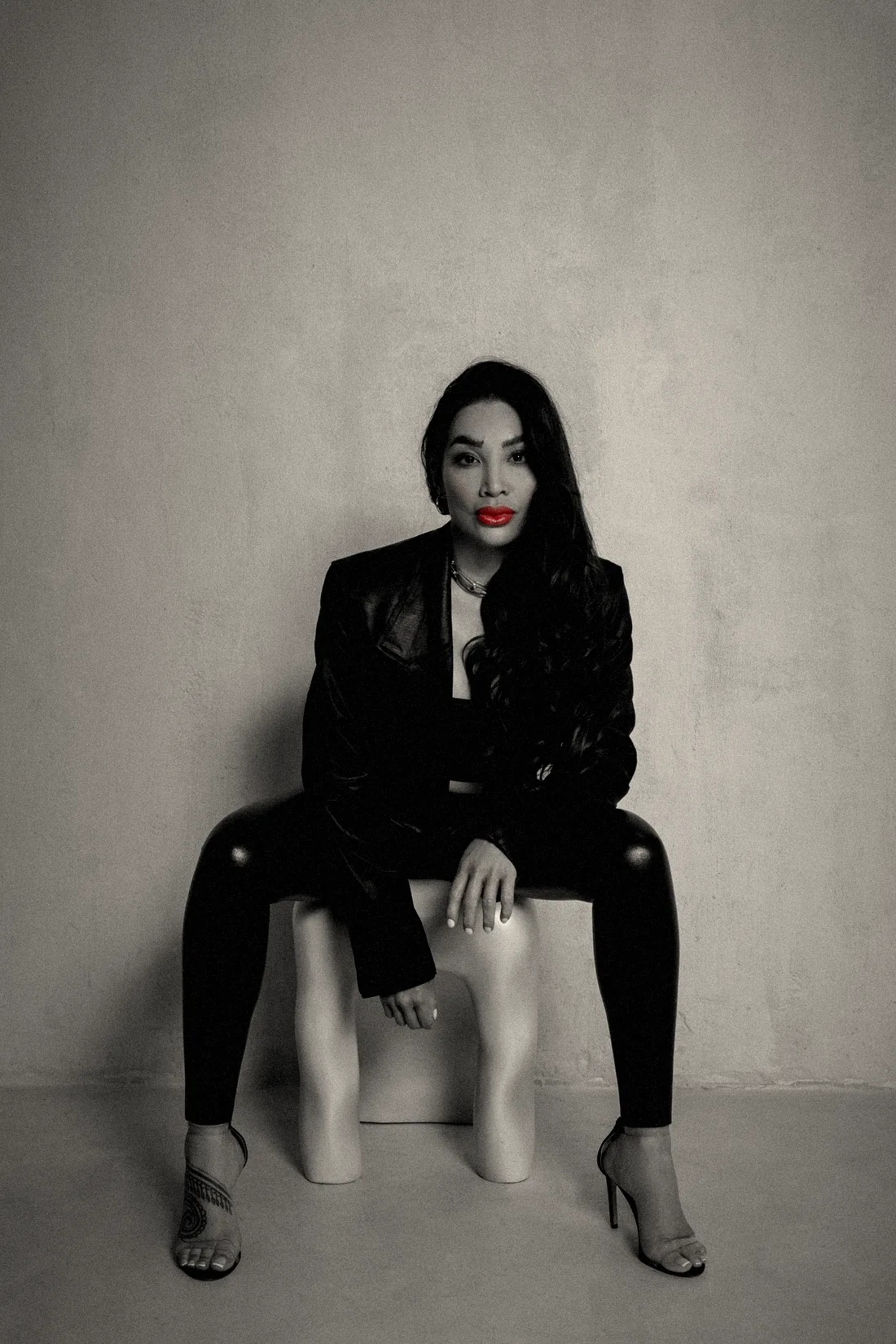 Chayenne Mallari seated with her hand resting on a white stool